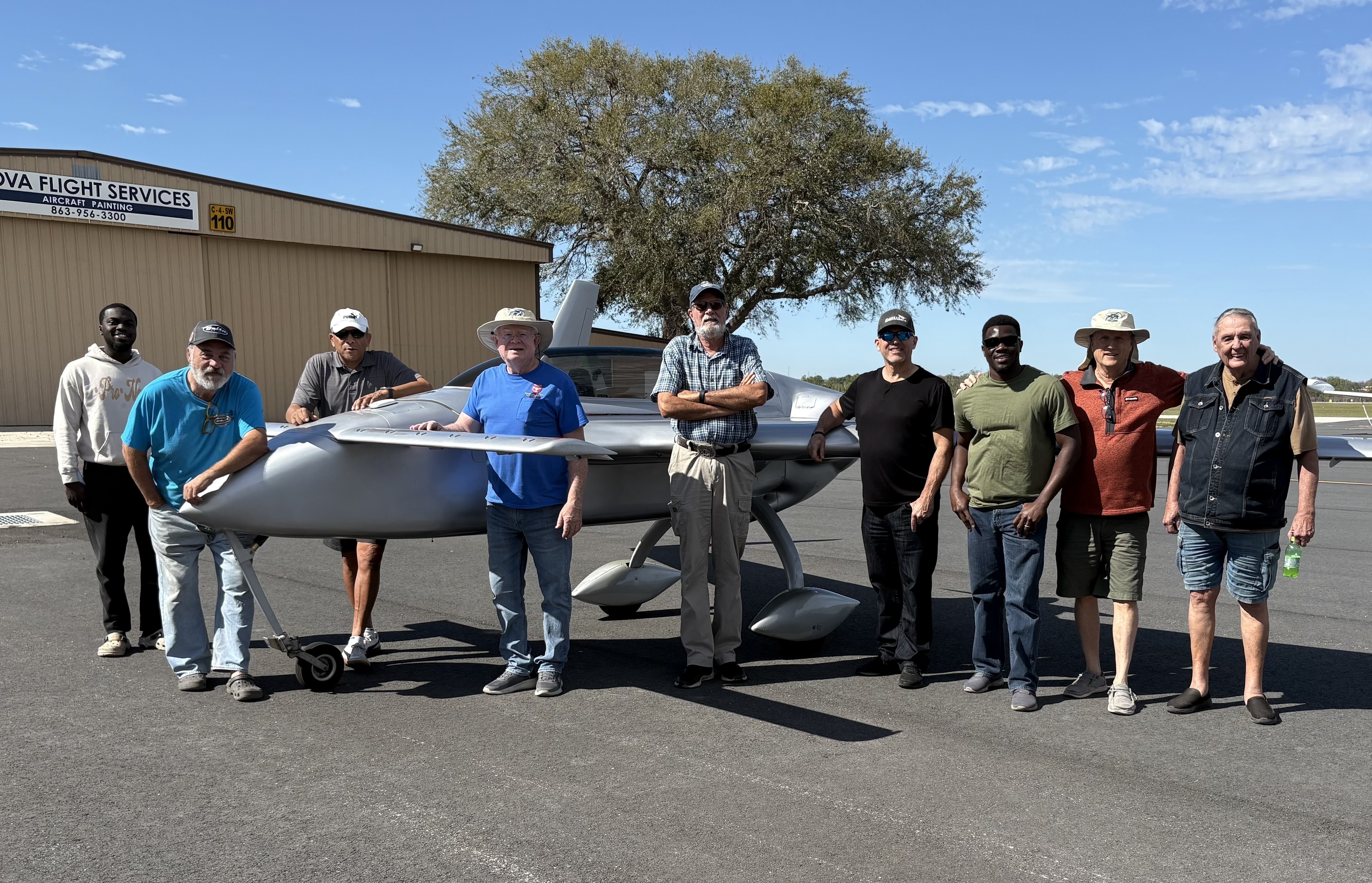 EAA Chapter 229 members gathered around a homebuilt aircraft at KGIF Gilbert Field