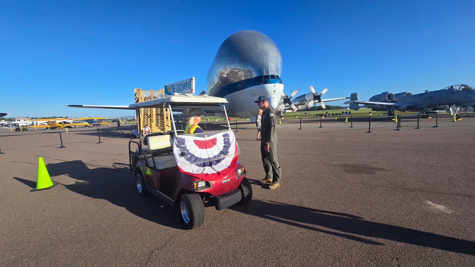 EAA Chapter 229 volunteer golf cart on the KLAL ramp with the NASA Super Guppy and A-10 Warthog in the background