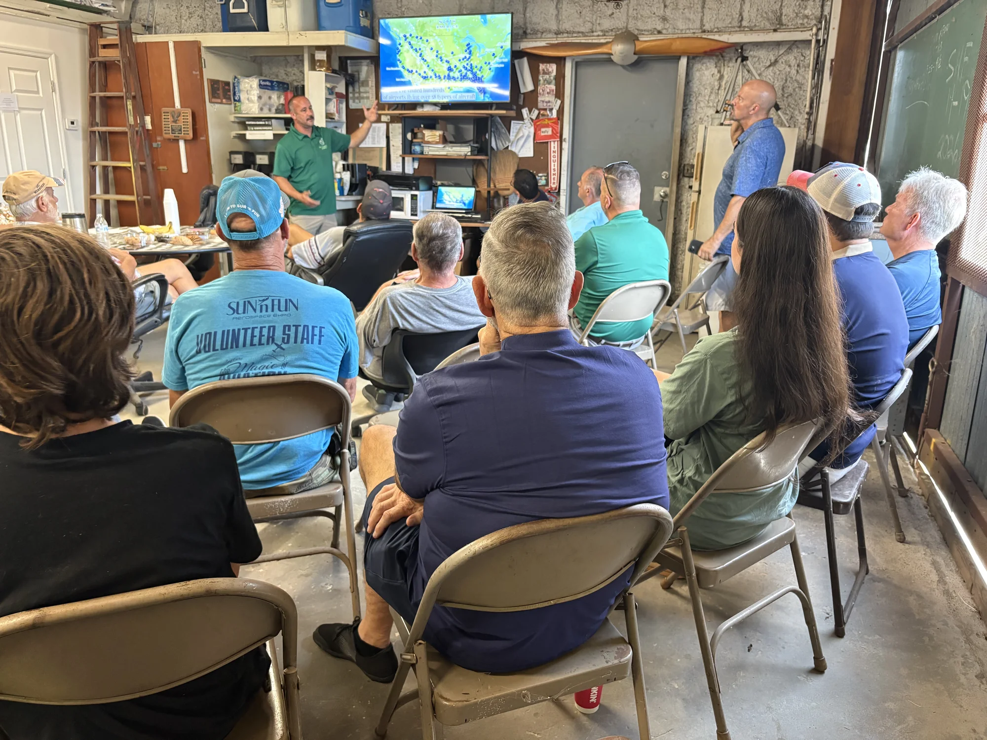 A full house at Hangar 100 watching Patrick Blackwelder's ferry flight slides